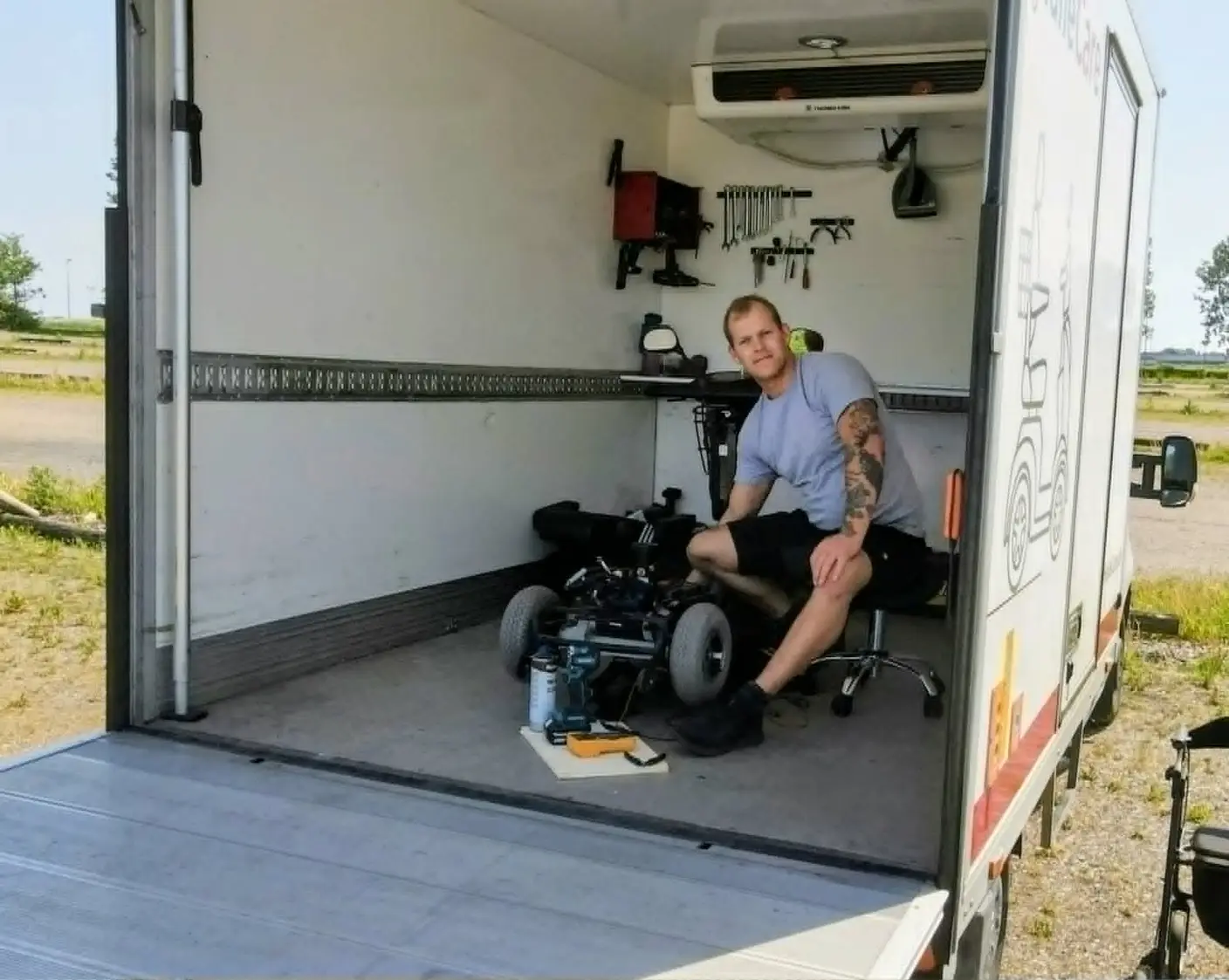 HalleCares mekaniker Kasper sidder og reparerer en el-scooter inde i det mobile værksted